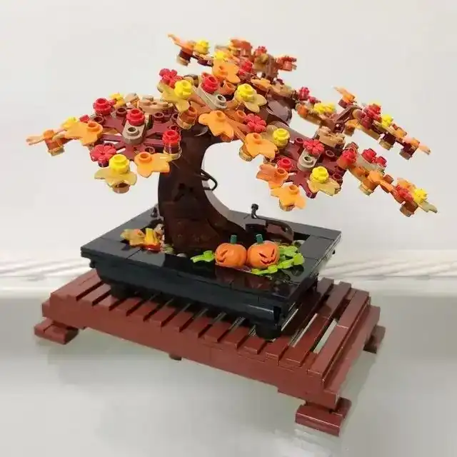 LEGO Bonsai Tree 10281 set displayed with orange, yellow, and red autumn leaves and small pumpkins in the pot.