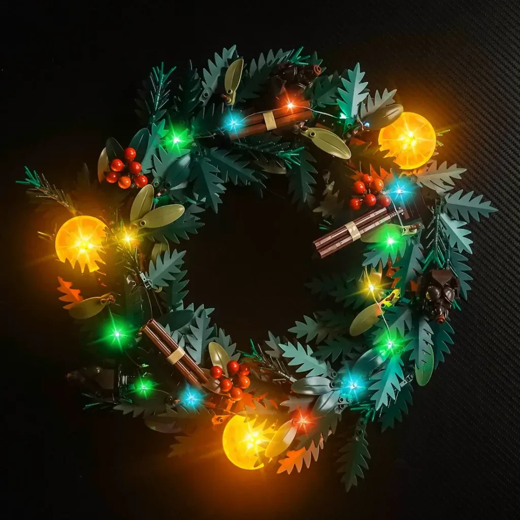 Full LEGO Icons Wreath 10340 decorated with BrickBling lights glowing in warm white, green, and yellow tones.