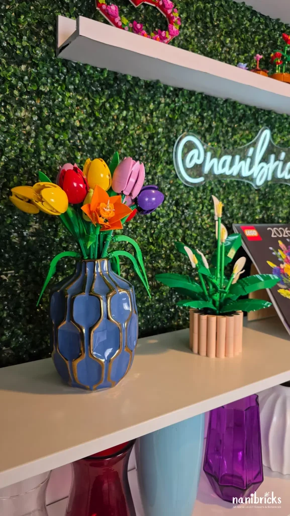 LEGO Botanicals Peace Lily displayed on a shelf alongside colorful LEGO flower arrangements and decorative vases.