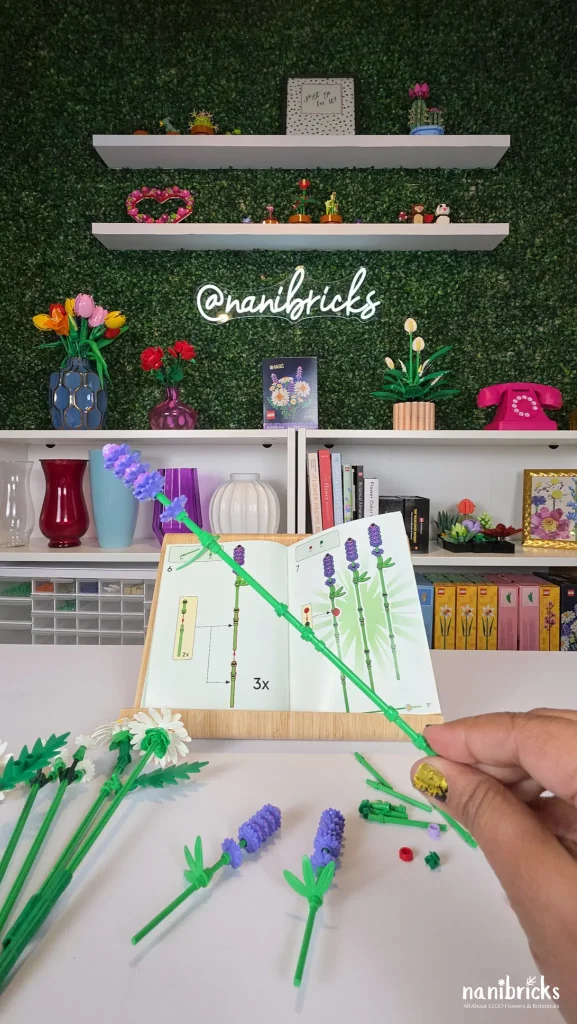 Lavender stem from LEGO Botanicals Daisies (11508) held during build process with instruction booklet in background