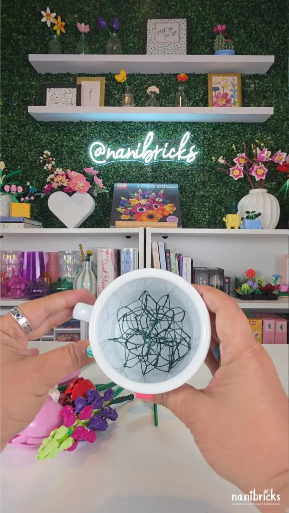 florist netting inside mug holding LEGO flower arrangement stems in place