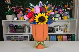 Sunshine Garden LEGO flower arrangement with yellow sunflowers, red roses, pink tulips, orange ranunculus, lavender, blue cornflowers, and cow parsley in a peach-colored LEGO vase.